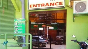 A hotel entrance with a green facade, a signboard, and a motorcycle parked in front. - Asia Novo Boutique Hotel - Ozamiz (Ozamiz)
