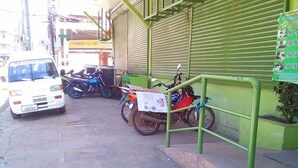 A street view with a white van parked on the side, a motorcycle, and a green metal structure. - Asia Novo Boutique Hotel - Ozamiz (Ozamiz)