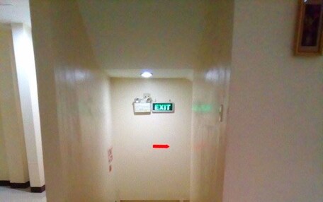 A narrow hallway with a sign indicating an exit.