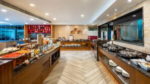 A buffet with various food items and a brick wall. - Country Inn & Suites By Radisson Jammu (Jammu)