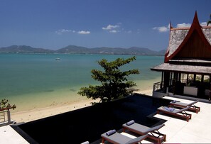 A poolside area with lounge chairs and a view of the beach and ocean. - Anayara Luxury Retreat Panwa Resort (Wichit)