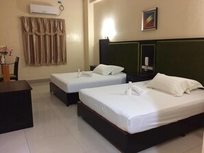 A hotel room with two single beds, a desk, a chair, an air conditioner, a telephone, and a painting on the wall. - Asia Novo Boutique Hotel - Oroquieta (Oroquieta)