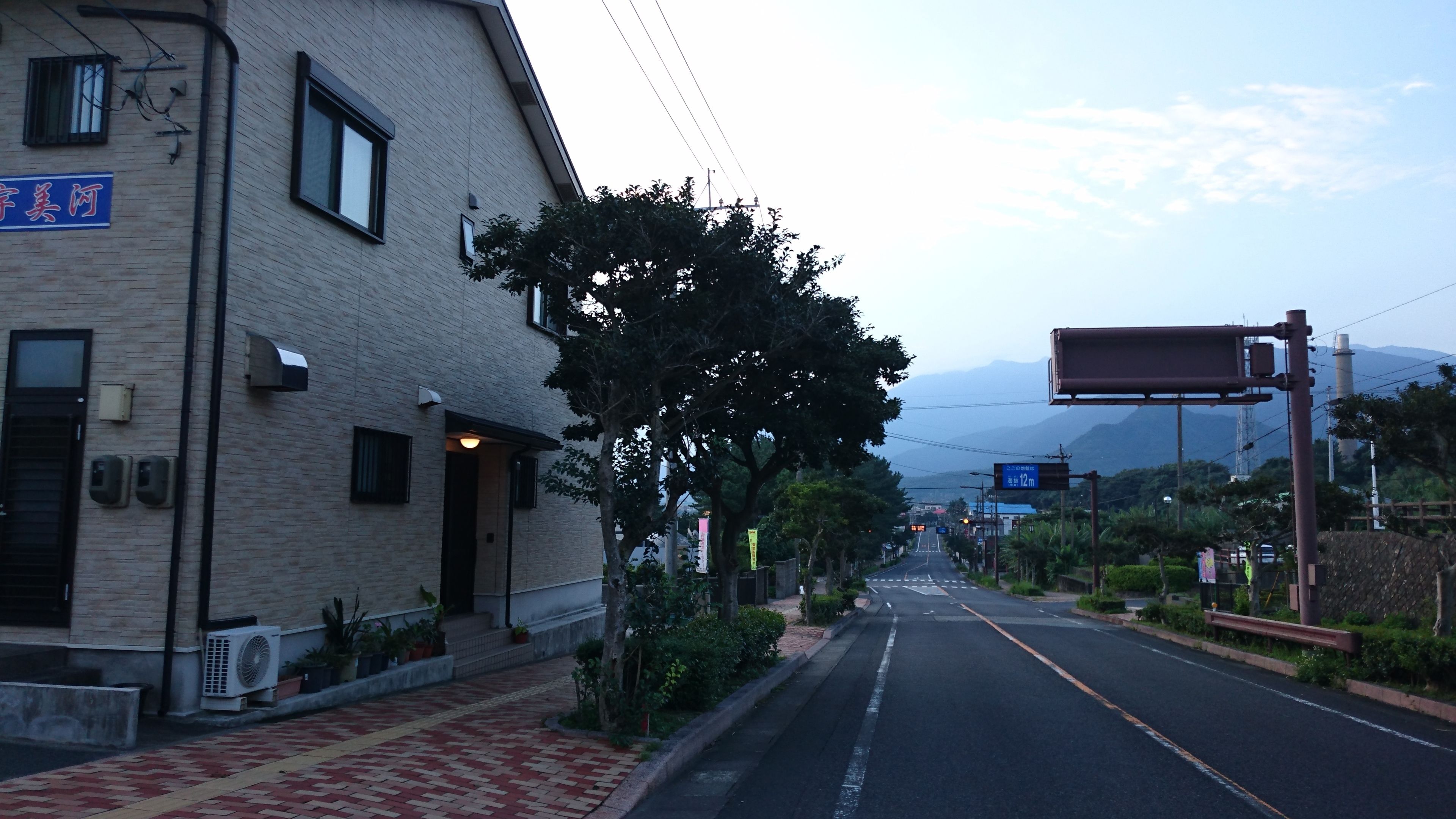 A building with a brick facade, a signboard, and a clear sky.