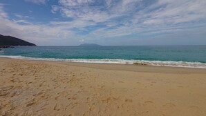 Une plage avec un ciel dégagé et une mer calme.