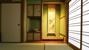 Una habitación tradicional japonesa con suelo de tatami, un divisor shoji y una puerta corredera.