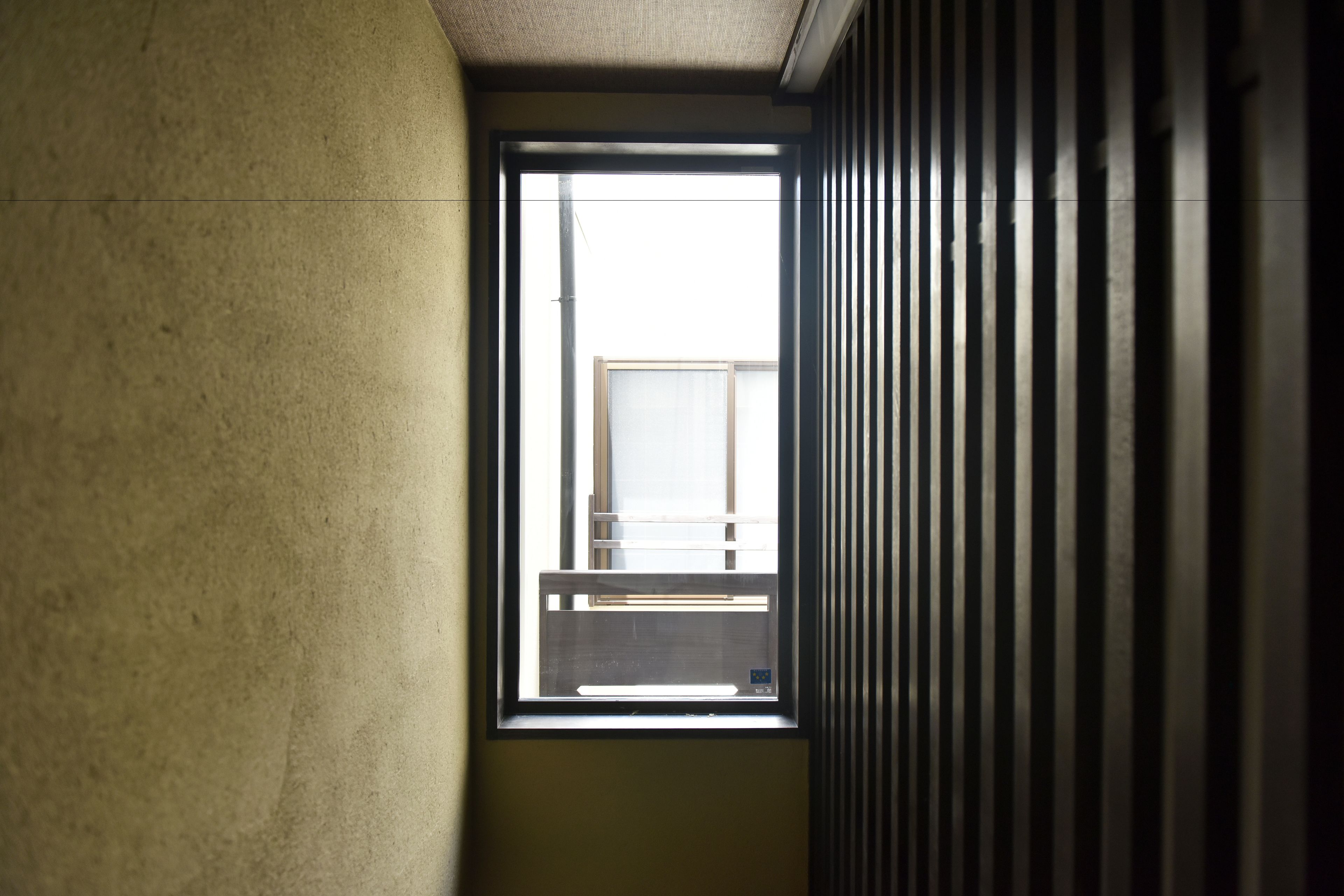 Un pasillo estrecho con una ventana que da a un balcón.