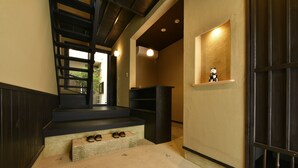 Una escalera que lleva a un rellano con un estante pequeño y una figurita.