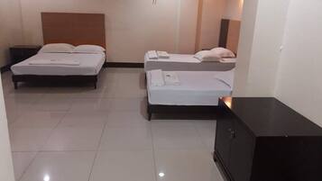 A hotel room with two beds, a dark-colored cabinet, and a tiled floor.