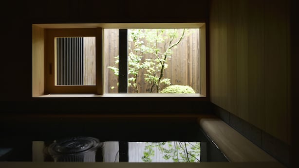 A room with a window overlooking a wooden fence and greenery. - KURAYA Nanseicho (Kyoto)