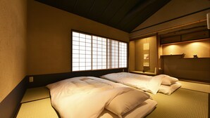 A traditional Japanese-style room with tatami flooring, a shoji screen window, and a low ceiling. - KURAYA Nanseicho (Kyoto)