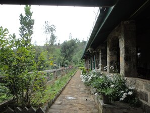 A stone pathway leading to a traditional building with a green roof and potted plants. - Castlereigh Holiday Bungalow (Hatton)