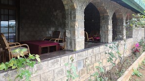 A stone structure with arches, a table, and chairs. - Castlereigh Holiday Bungalow (Hatton)