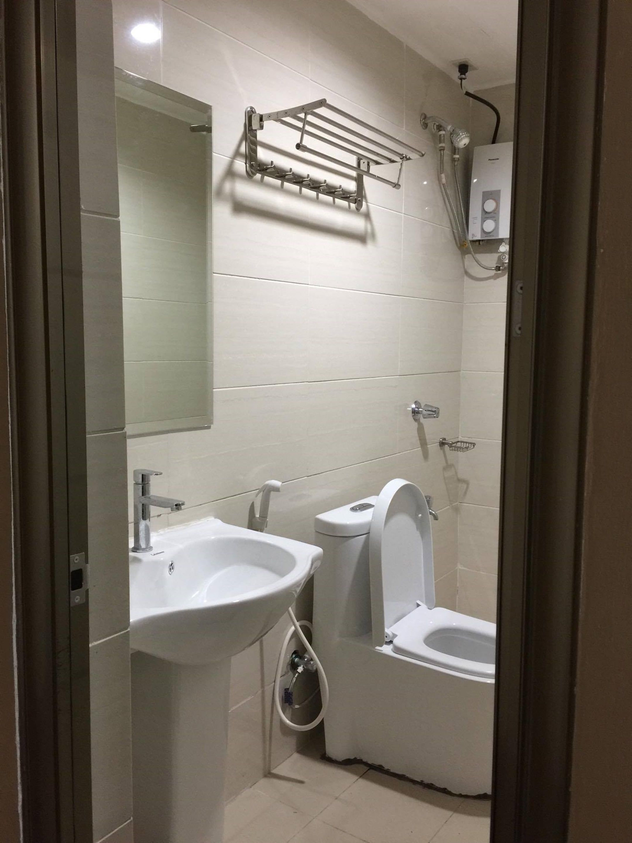 A modern bathroom with a sink, toilet, and shower.