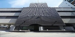 Un edificio moderno con fachada de metal corrugado y una entrada destacada.