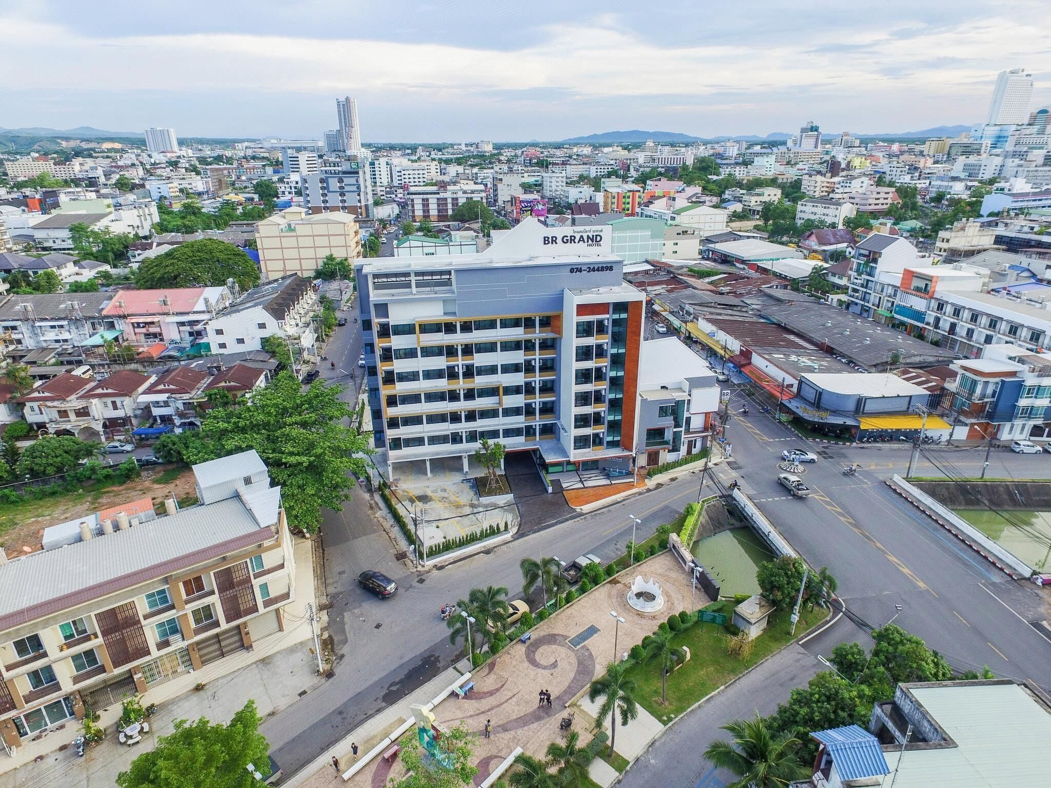 A multi-story hotel with a modern design, located in a busy urban area with surrounding buildings and a clear sky.