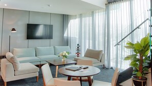Una sala de estar moderna con un sofá, sillones, una mesa de centro y un televisor.