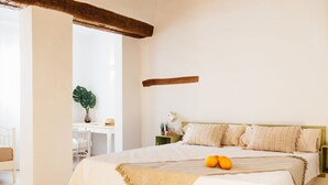 A bedroom with a bed, bedside table, lamp, and a potted plant. - OttoH Charm Stay (Valencia)