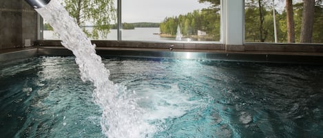 Una piscina techada, sillones reclinables de piscina