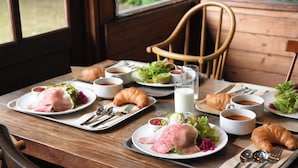 Een ontbijttafel met croissants, eieren en koffie.