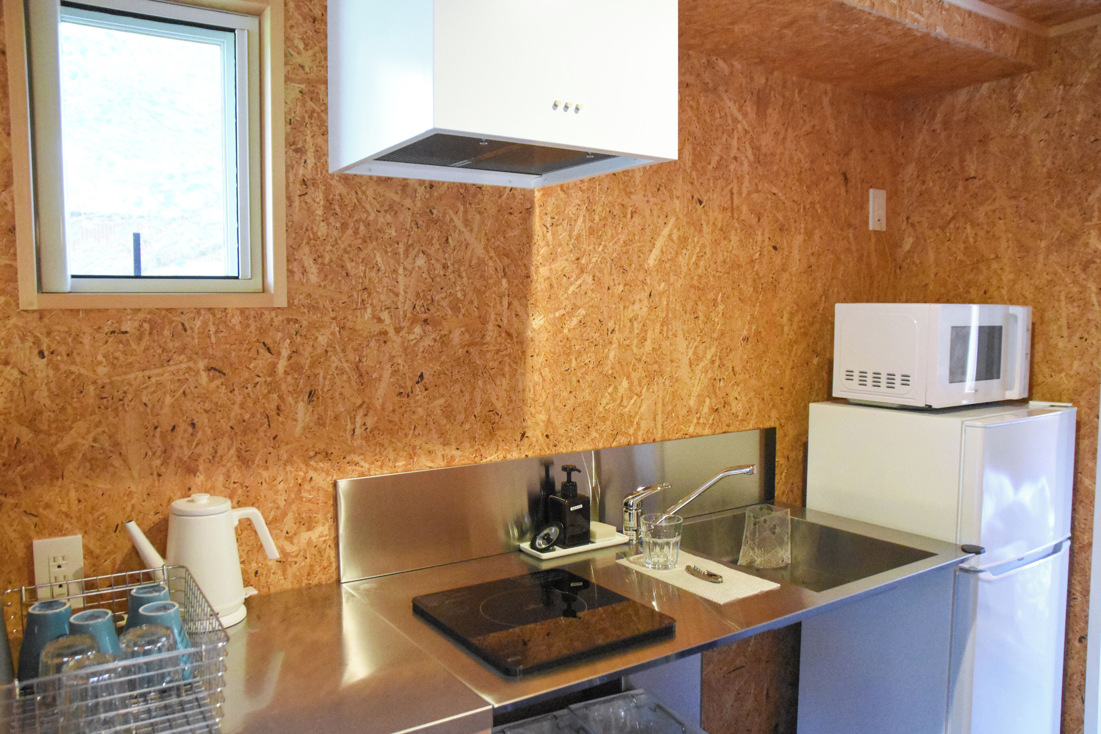 A kitchen with a microwave, kettle, and coffee maker.