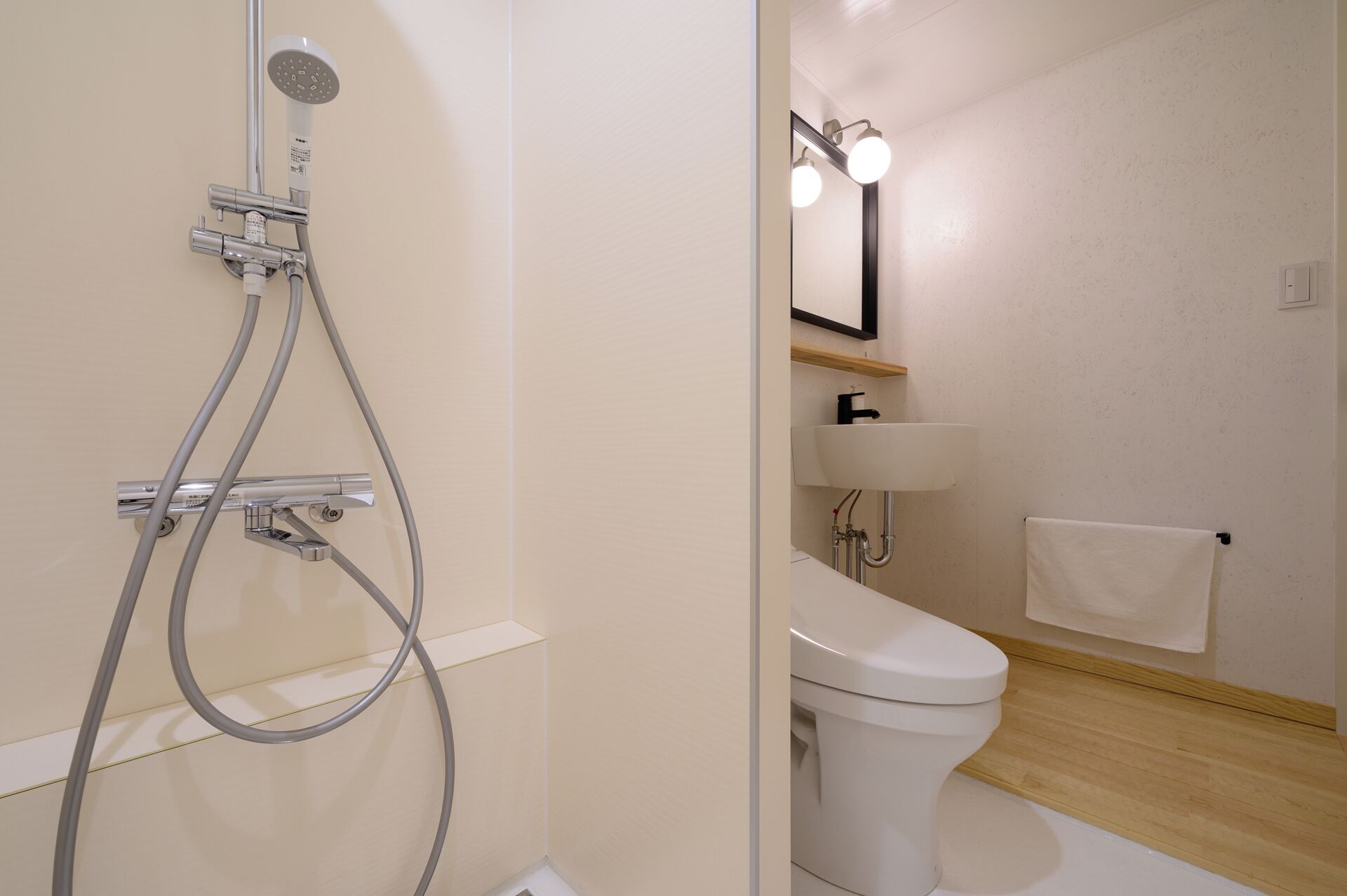 Un baño con ducha, inodoro, lavamanos y espejo.