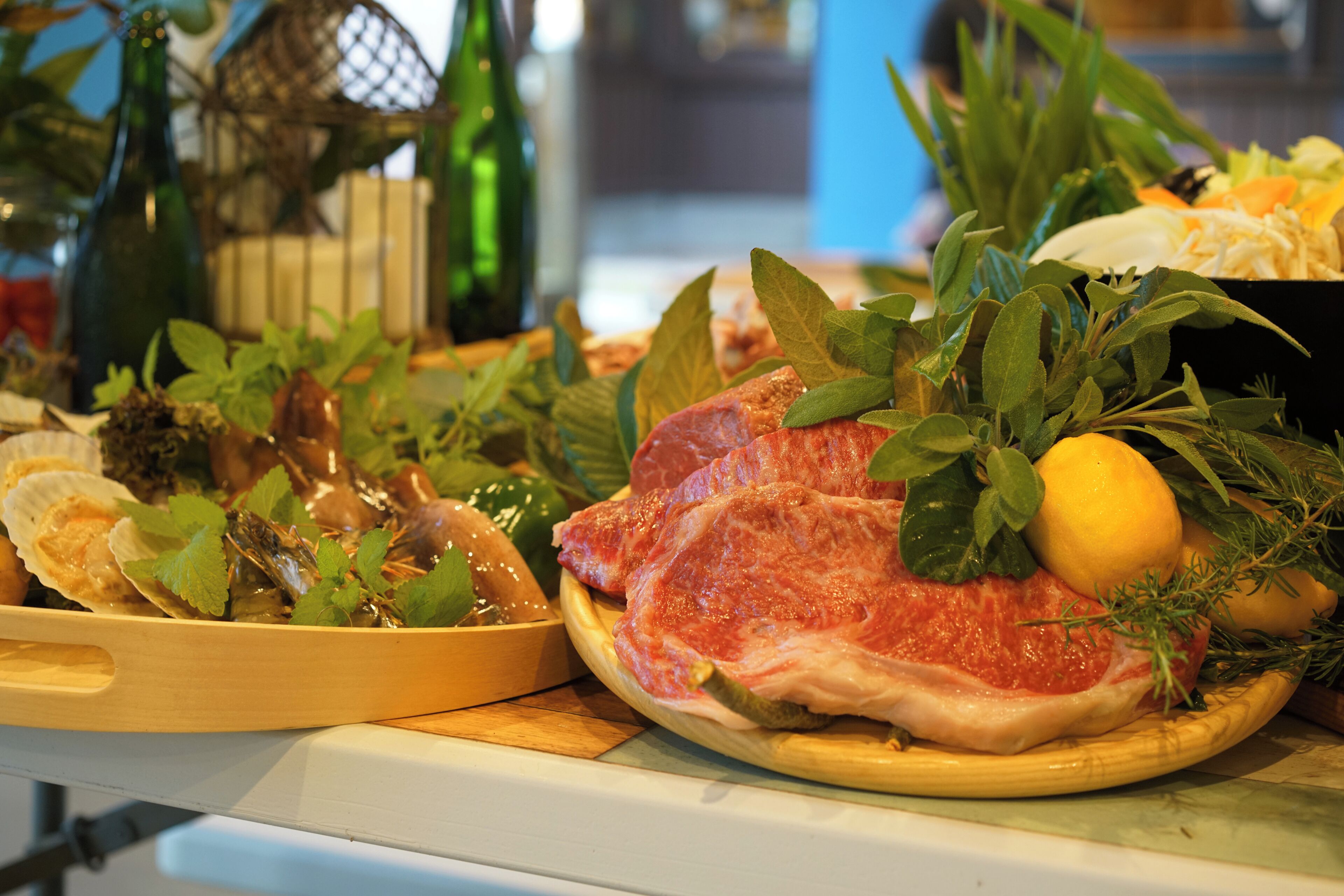 Une variété de fruits de mer frais et d’herbes aromatiques présentés sur un plateau en bois.