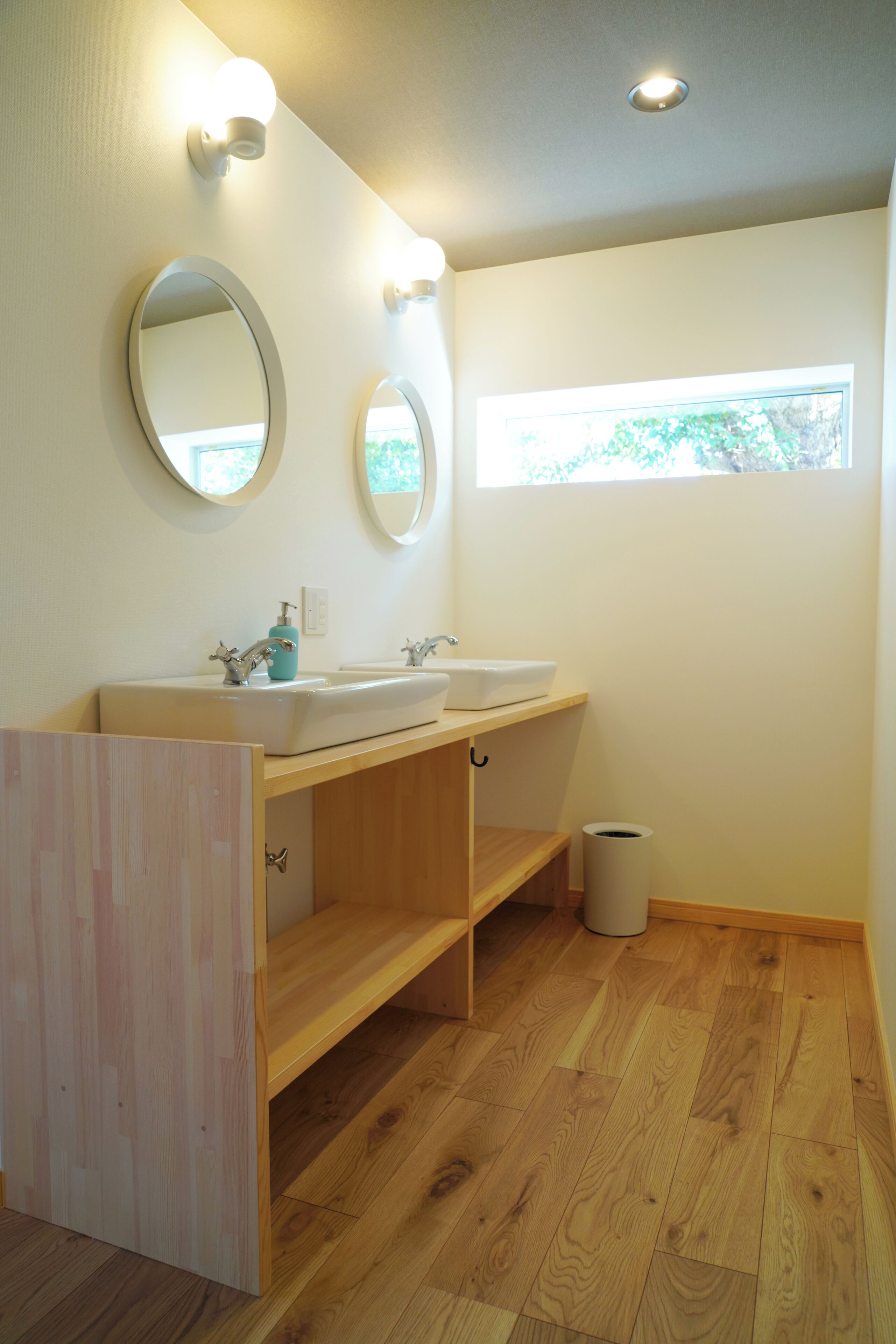 A bathroom with two sinks, a mirror, and a window.
