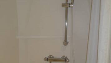 A shower with a handheld showerhead and a handheld faucet.