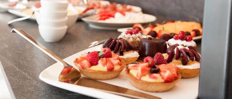 A dessert platter with various fruit-topped pastries on a white plate.