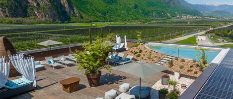 Terraza en la azotea con mobiliario exterior, piscina y vistas a viñedos y montañas.