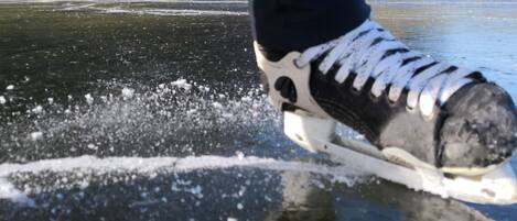 A close-up of a person ice-skating on a frozen surface with a mountainous landscape in the background.