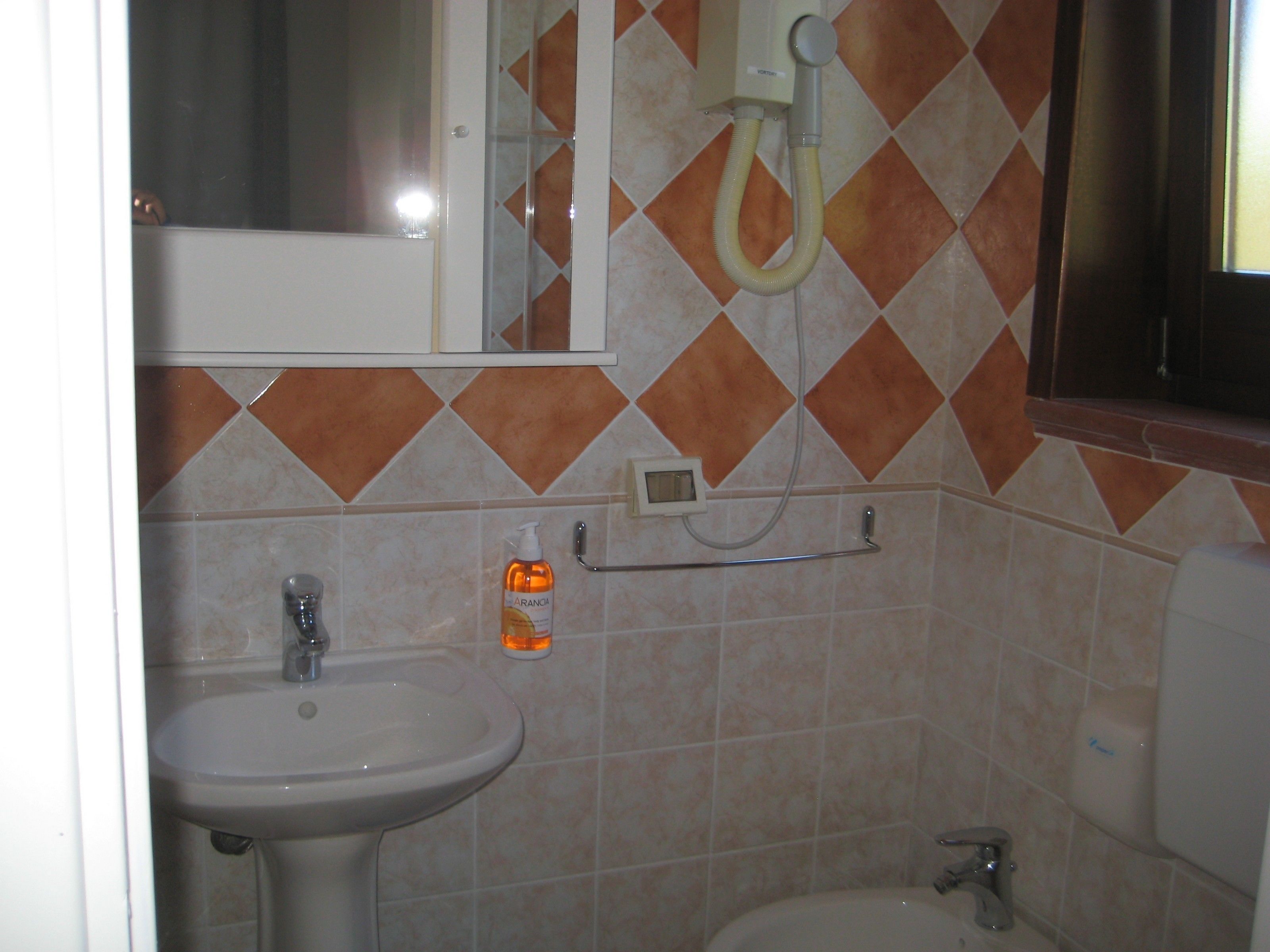 A bathroom with a sink, toilet, and shower.