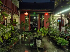 A traditional building with a wet courtyard, potted plants, and red lanterns. - Shaoxing Luxun Native Place Youth Hostel (Shaoxing)