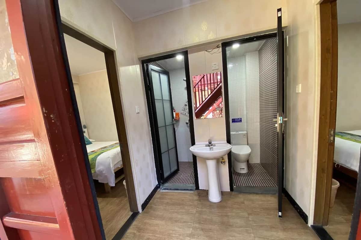 A bathroom with a sink, toilet, and a mirror.