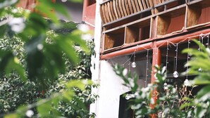 A building with a red facade, wooden balconies, and hanging spherical decorations. - Shaoxing Luxun Native Place Youth Hostel (Shaoxing)
