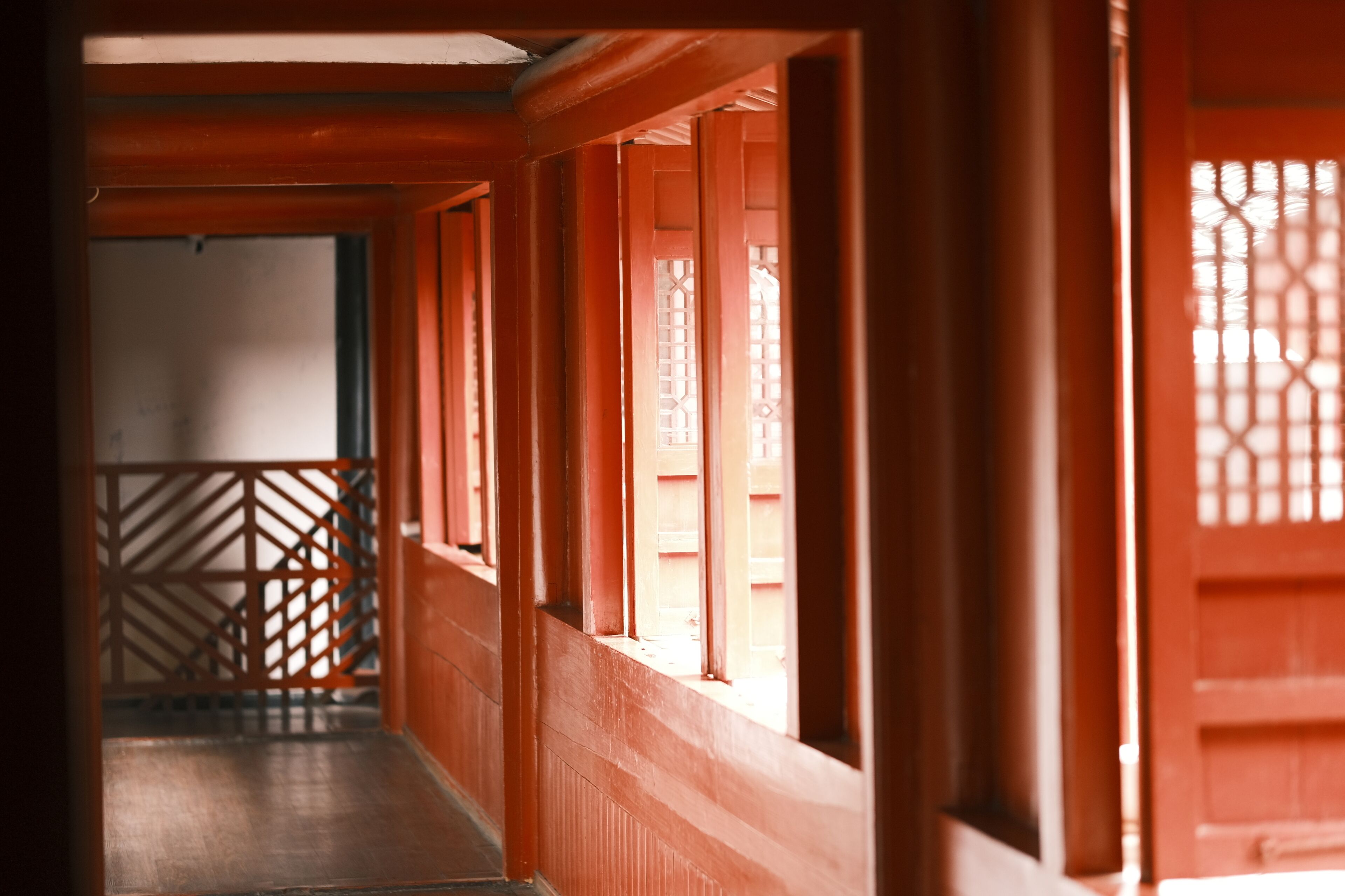 Un pasillo con puertas y ventanas de madera, que conduce a una habitación con vistas.