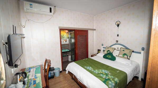 A bedroom with a bed, a TV, a heater, a window, and a door leading to a bathroom. - Shaoxing Luxun Native Place Youth Hostel (Shaoxing)
