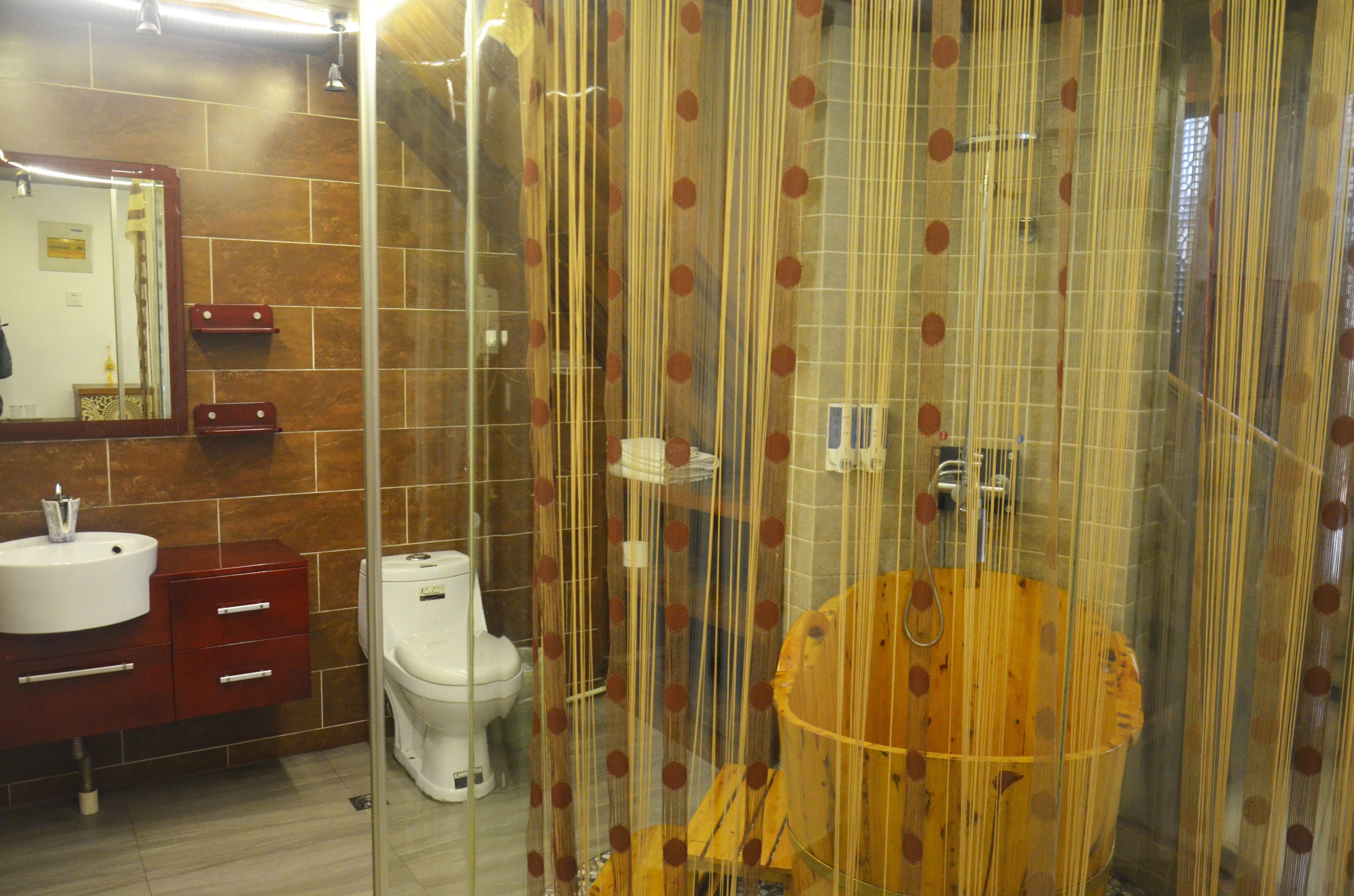A bathroom with a toilet, sink, and wooden vanity.