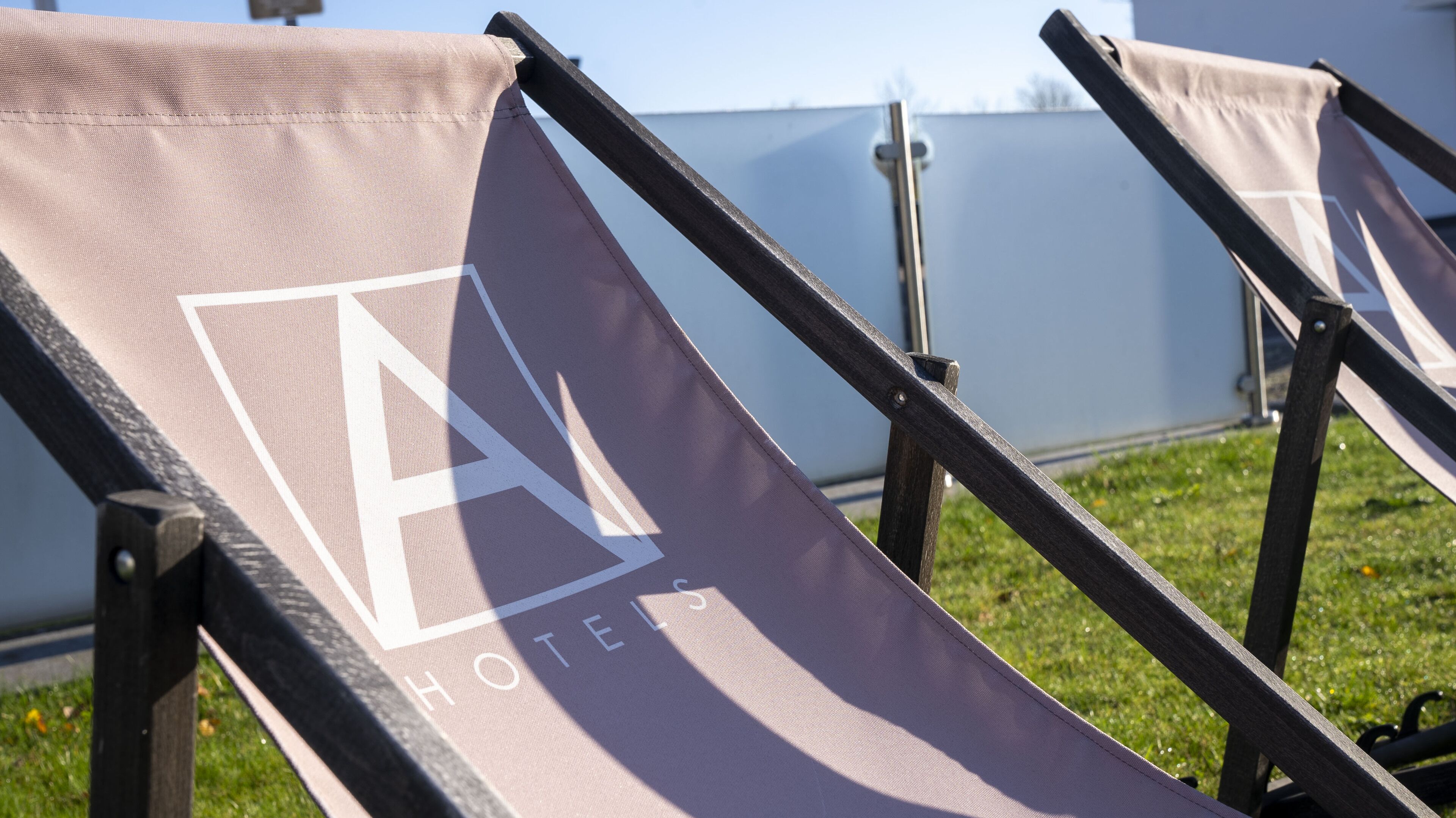 A row of sun loungers with a large 'A' logo, indicating a hotel or resort.