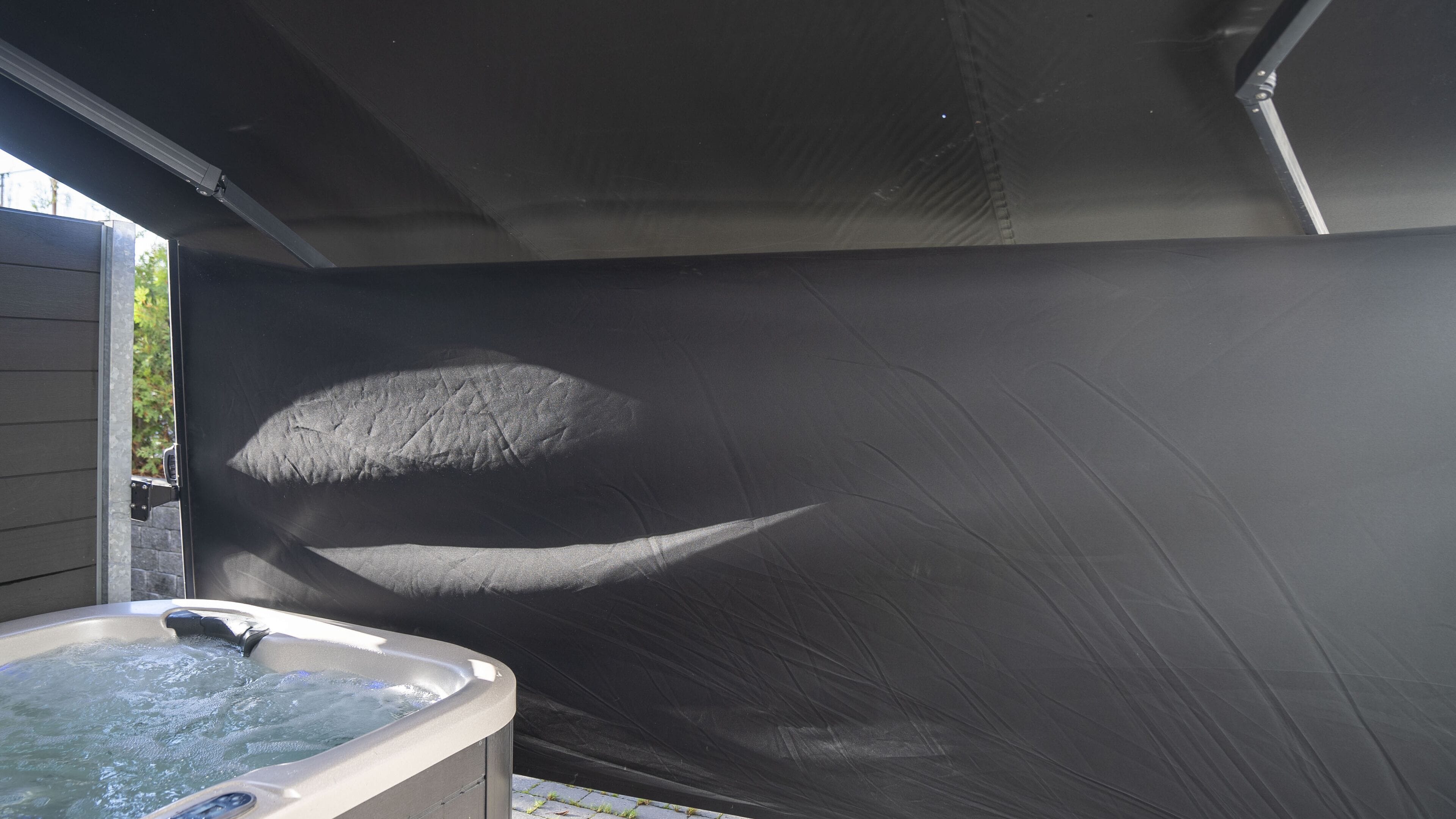 A hot tub with a dark, textured wall and a window to the left.