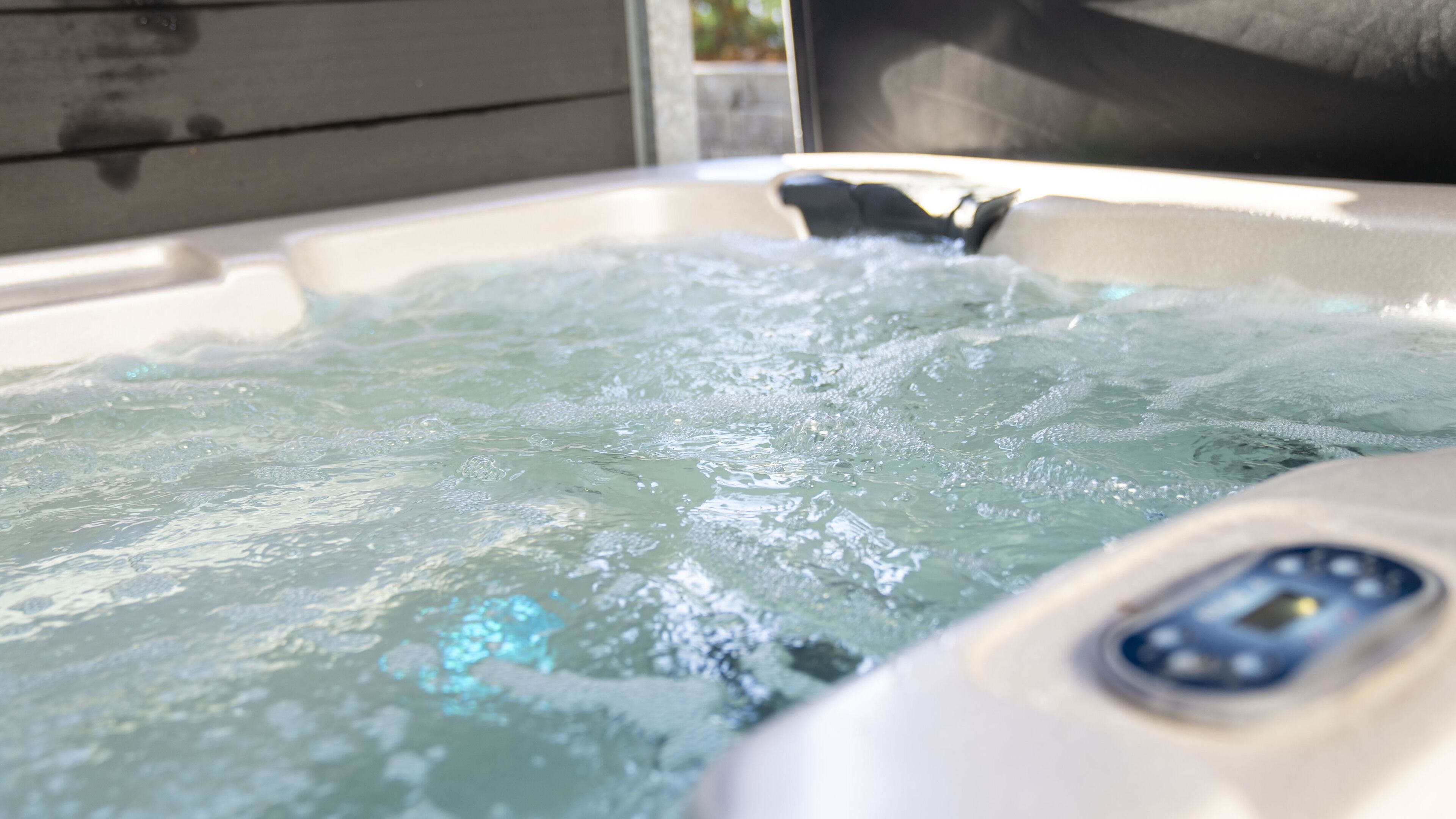 A hot tub with visible bubbles and a control panel.