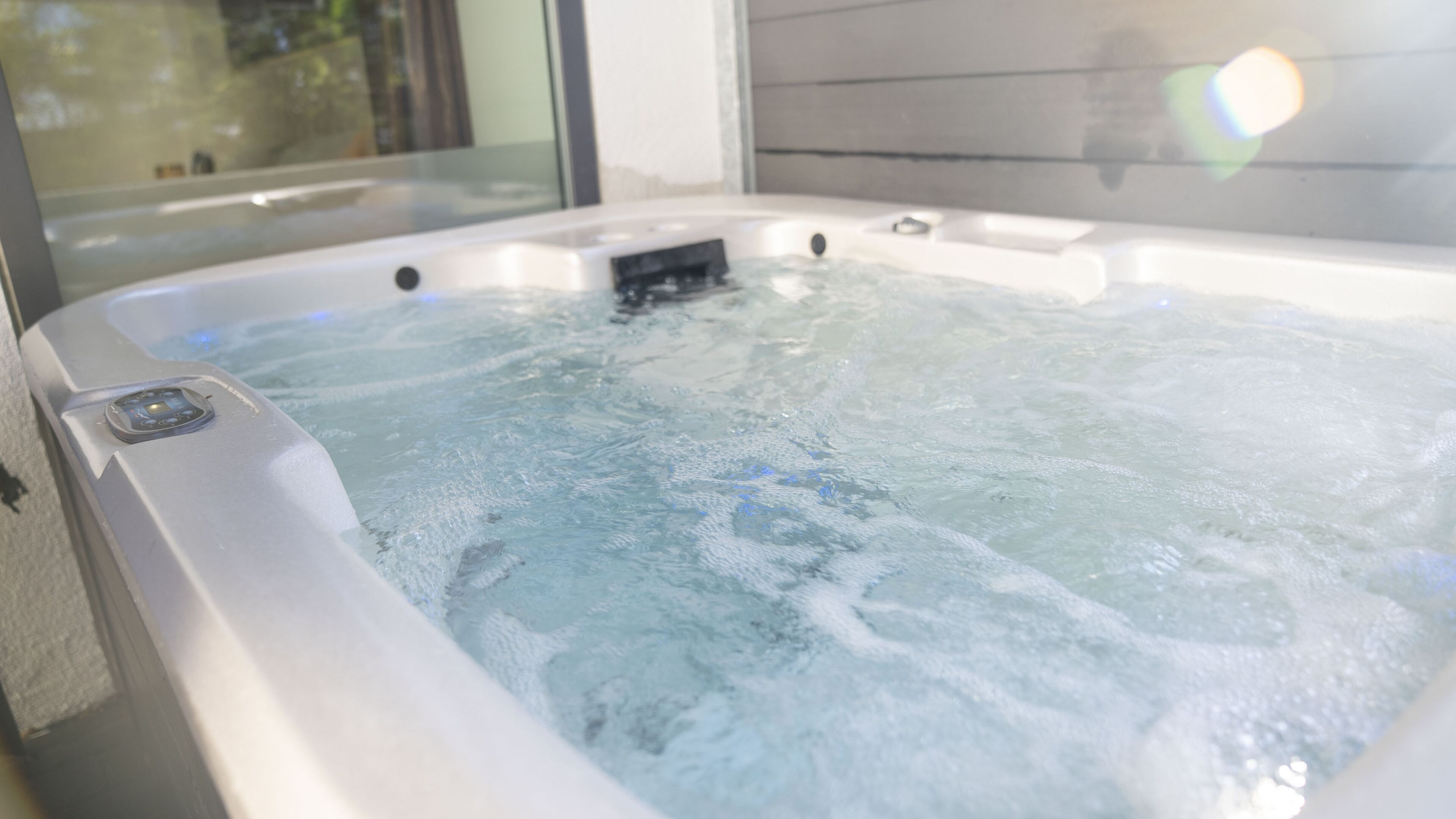 Un jacuzzi con panel de control y una ventana al fondo.