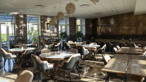 A spacious indoor dining area with multiple tables and chairs, large windows, and decorative crystal chandeliers. - A Hotels Glostrup (Brondby)