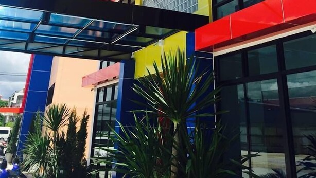 A modern building with a colorful facade, large windows, and a glass entrance. - Sakura Budget Hotel (Hat Yai)