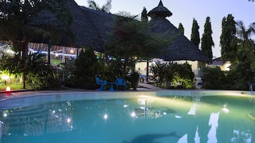 Una piscina al aire libre, sombrillas, sillones reclinables de piscina