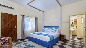 Un dormitorio con piso a cuadros, una cama con ropa de cama azul y blanca, una puerta de madera y una silla de mimbre.