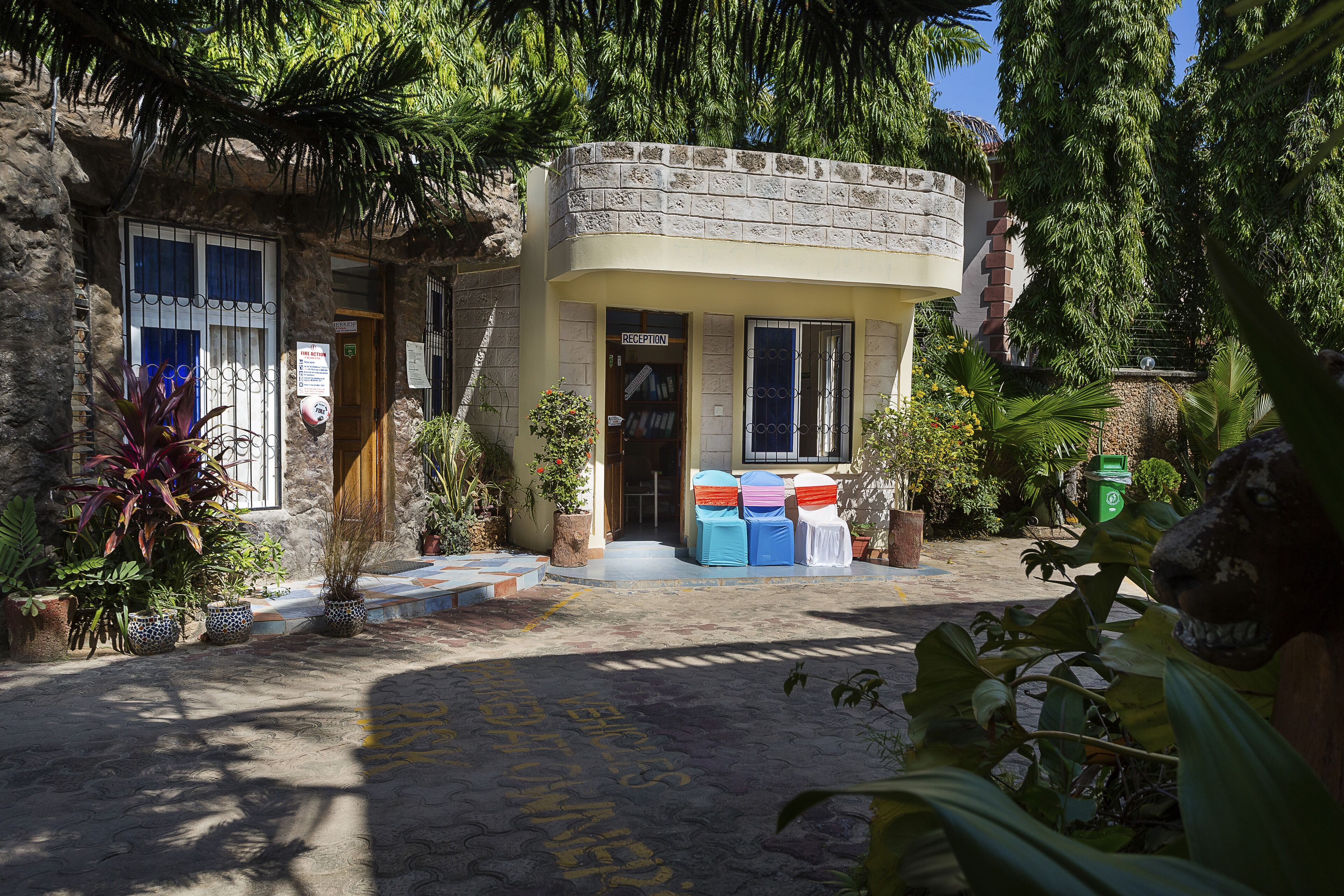 A stone building with a reception area, potted plants, and outdoor seating.