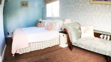 A bedroom with a bed, nightstand, and a chair.