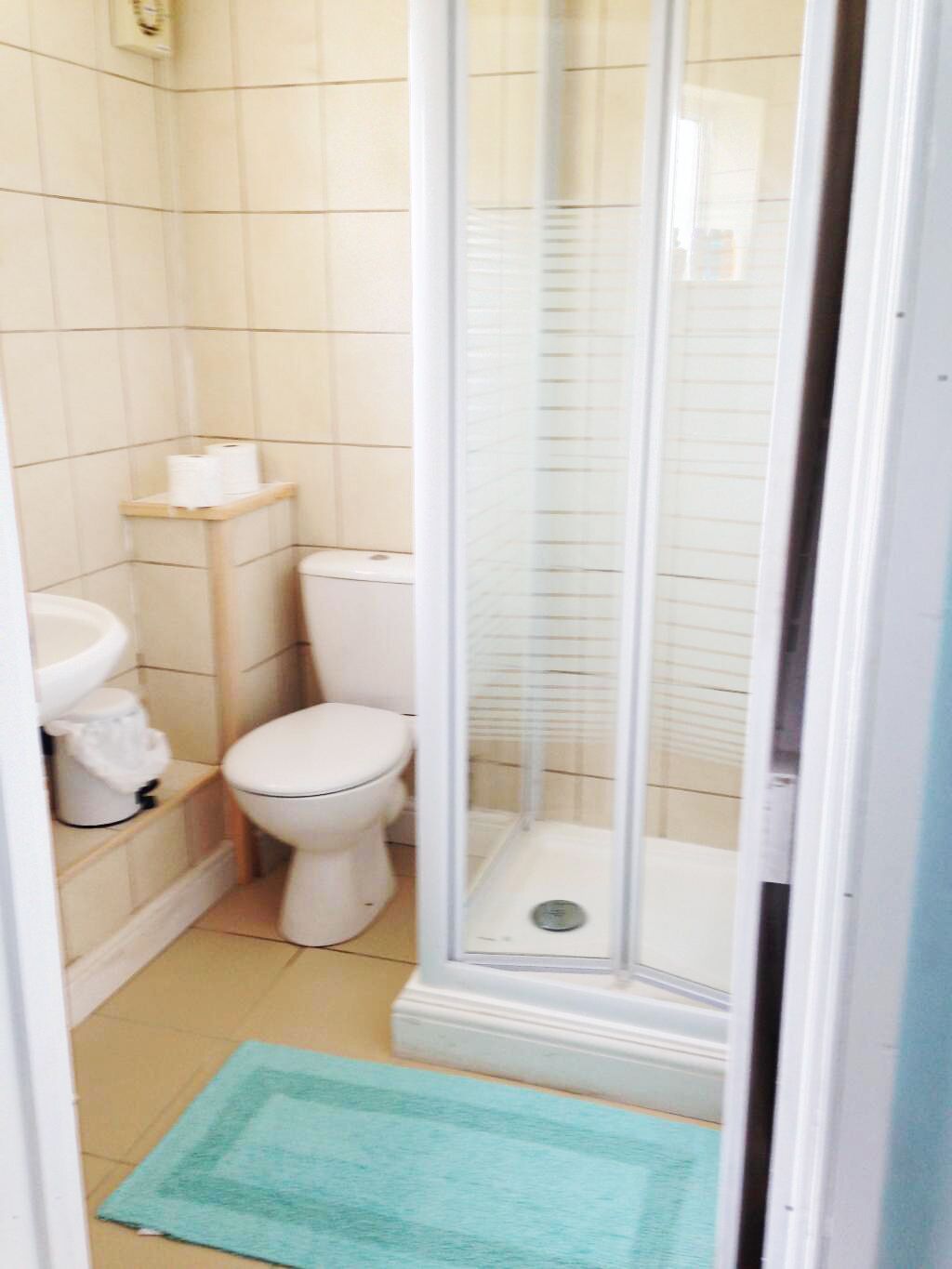 Ein kleines Badezimmer mit Toilette, Waschbecken und Duschkabine.