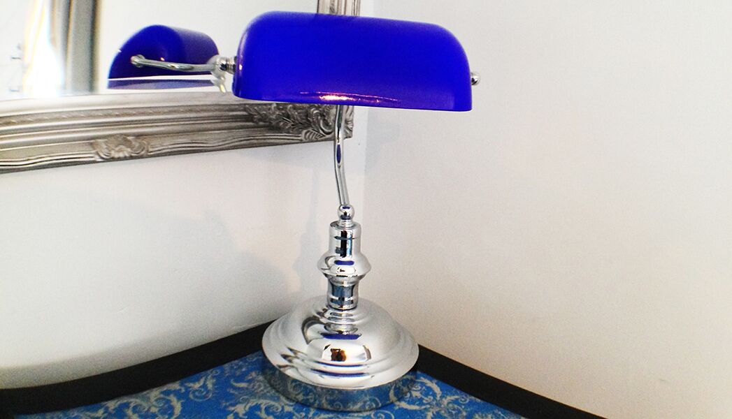Ein Blick in den Raum zeigt eine blaue Lampe auf einem blau-weißen, gemusterten Boden.